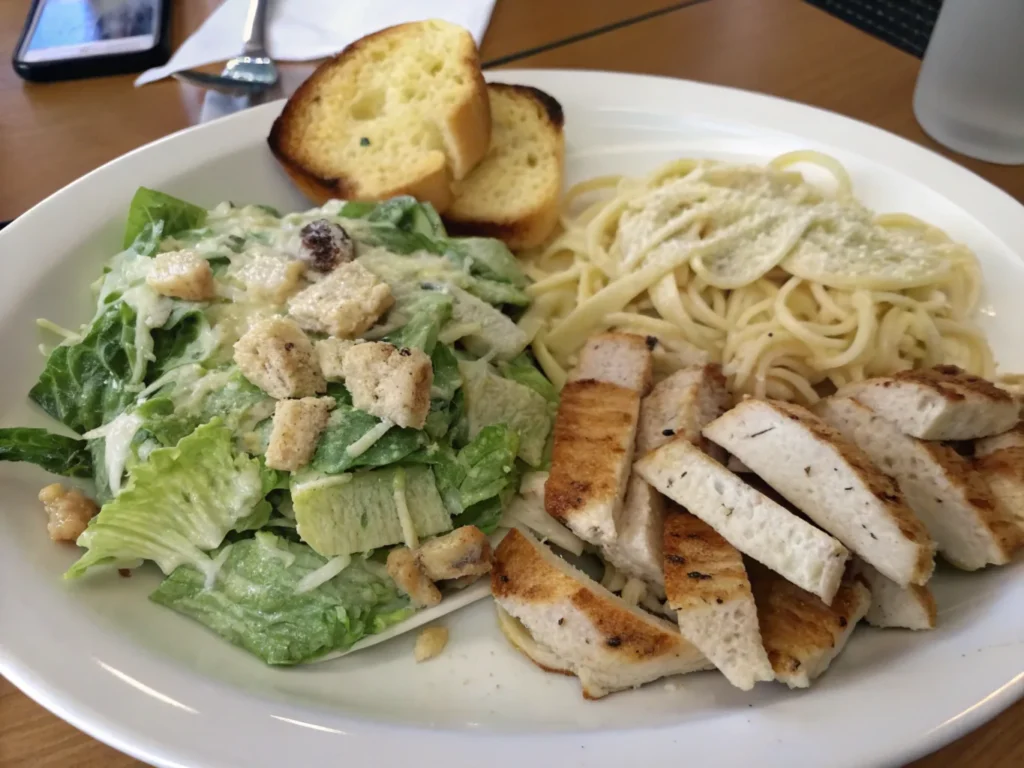 Chicken Alfredo served with garlic bread and Caesar salad, creating a perfect meal pairing.